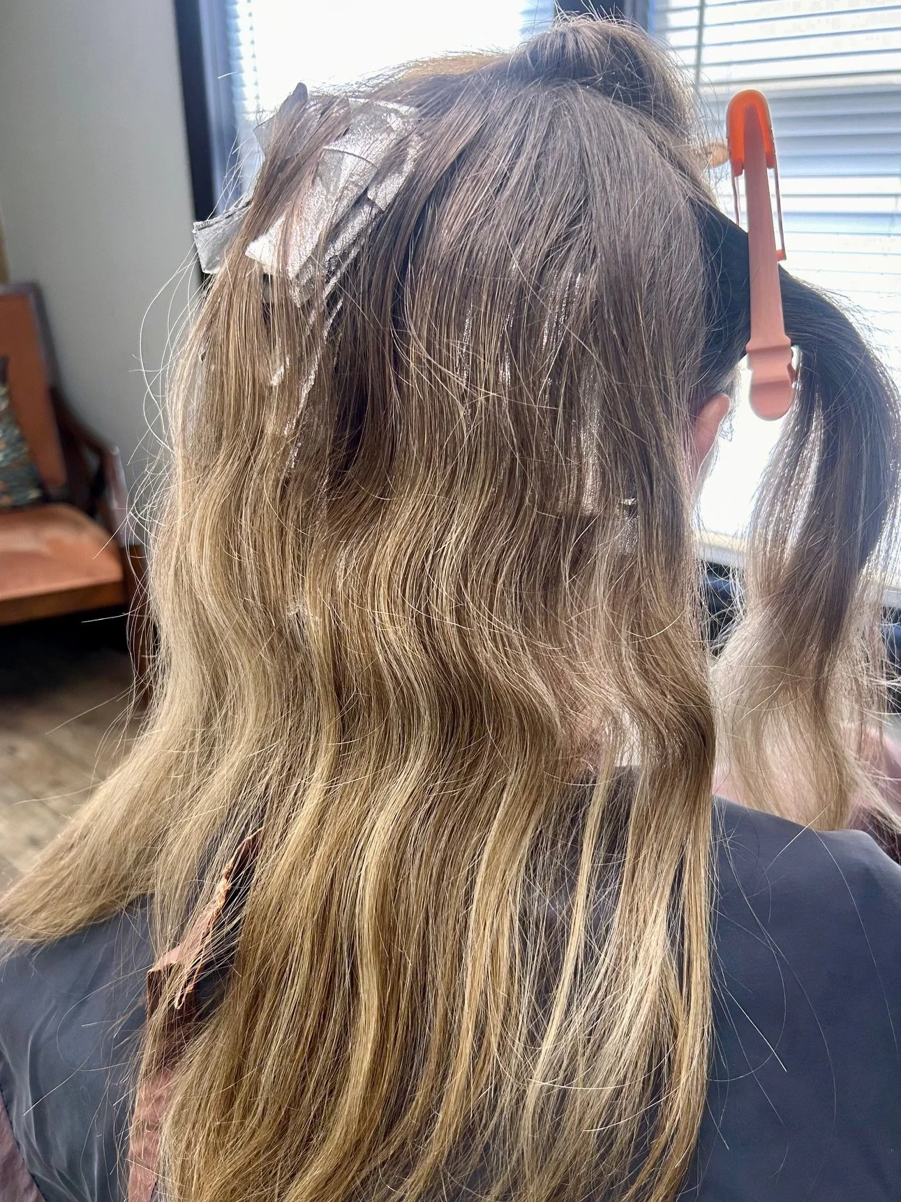 Hair with foil highlights and a hair clip on a person's head.