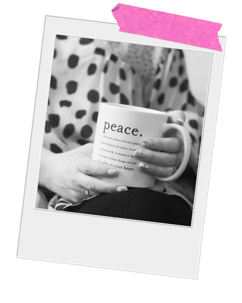Black and white photo of Emily Carroll Negi, LMFT holding a mug with the word "peace" printed on it.