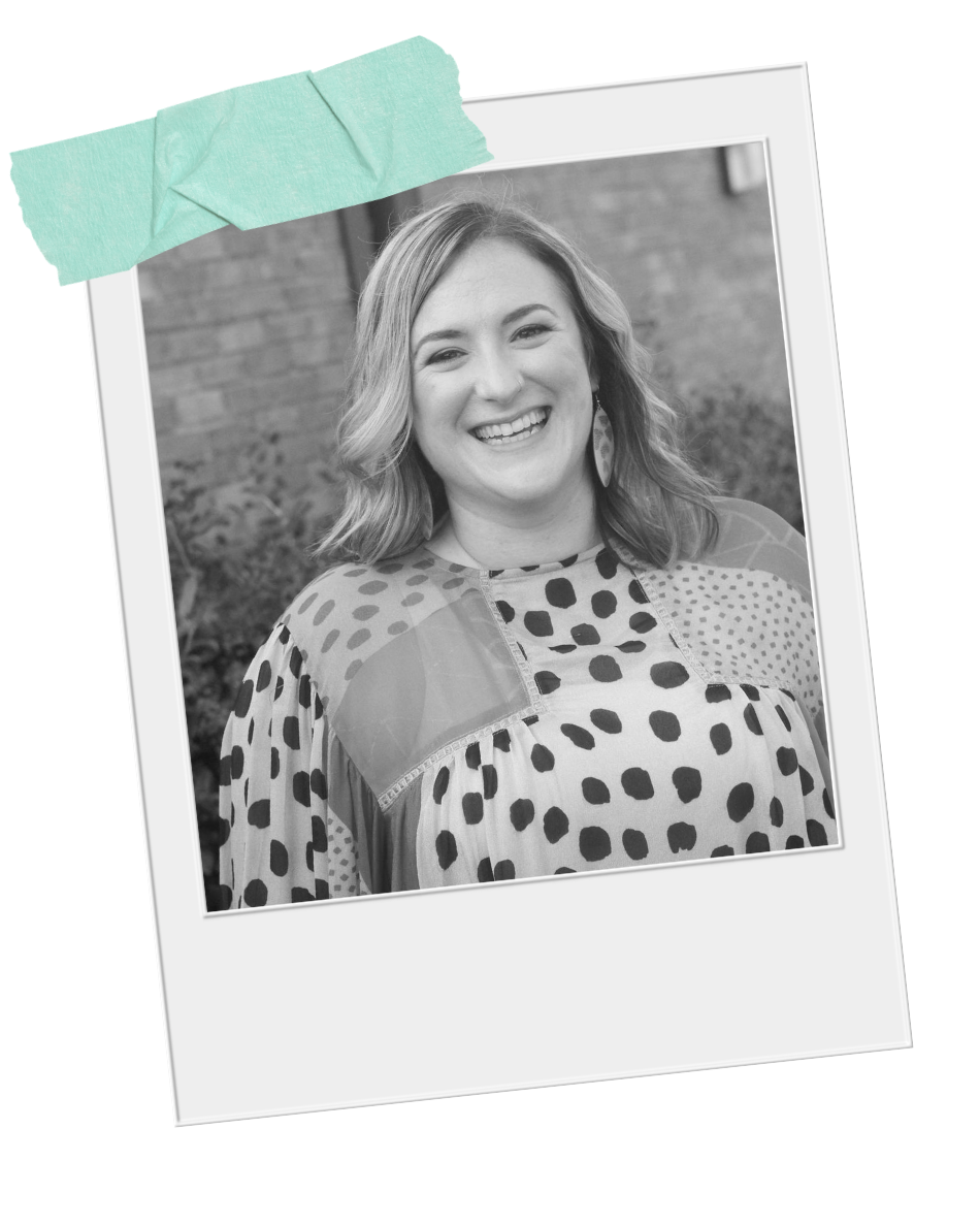 Black and white photo of Emily Carroll Negi, LMFT smiling, wearing a patterned top with polka dots and geometric shapes, standing outside her Nashville therapist office.