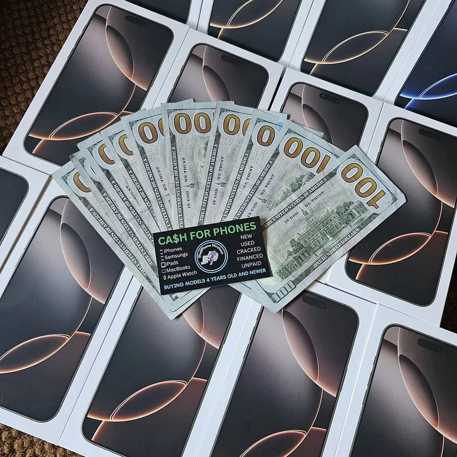 Multiple new iPhone boxes arranged on a surface with a fan of hundred-dollar bills and a business card reading "Cash for Phones" on top.
