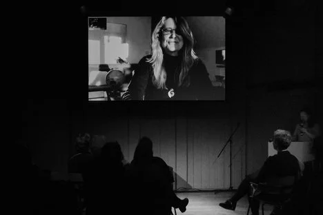 Black and white photo of author on a screen, chiaroscuro