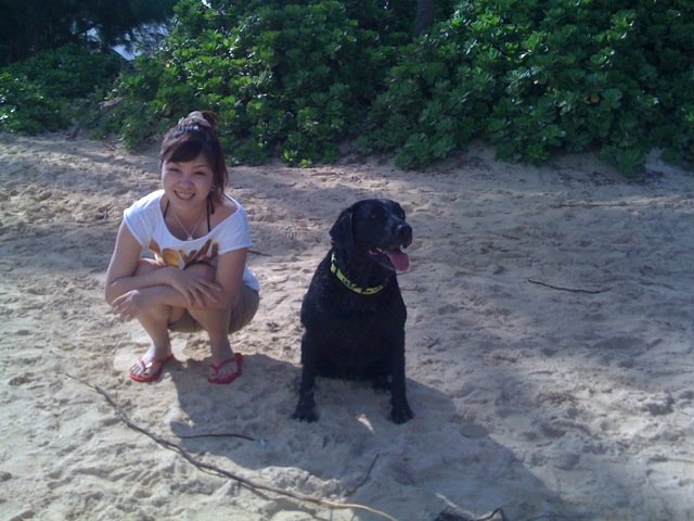 japanese woman sitting on the beach with lexi dogg
