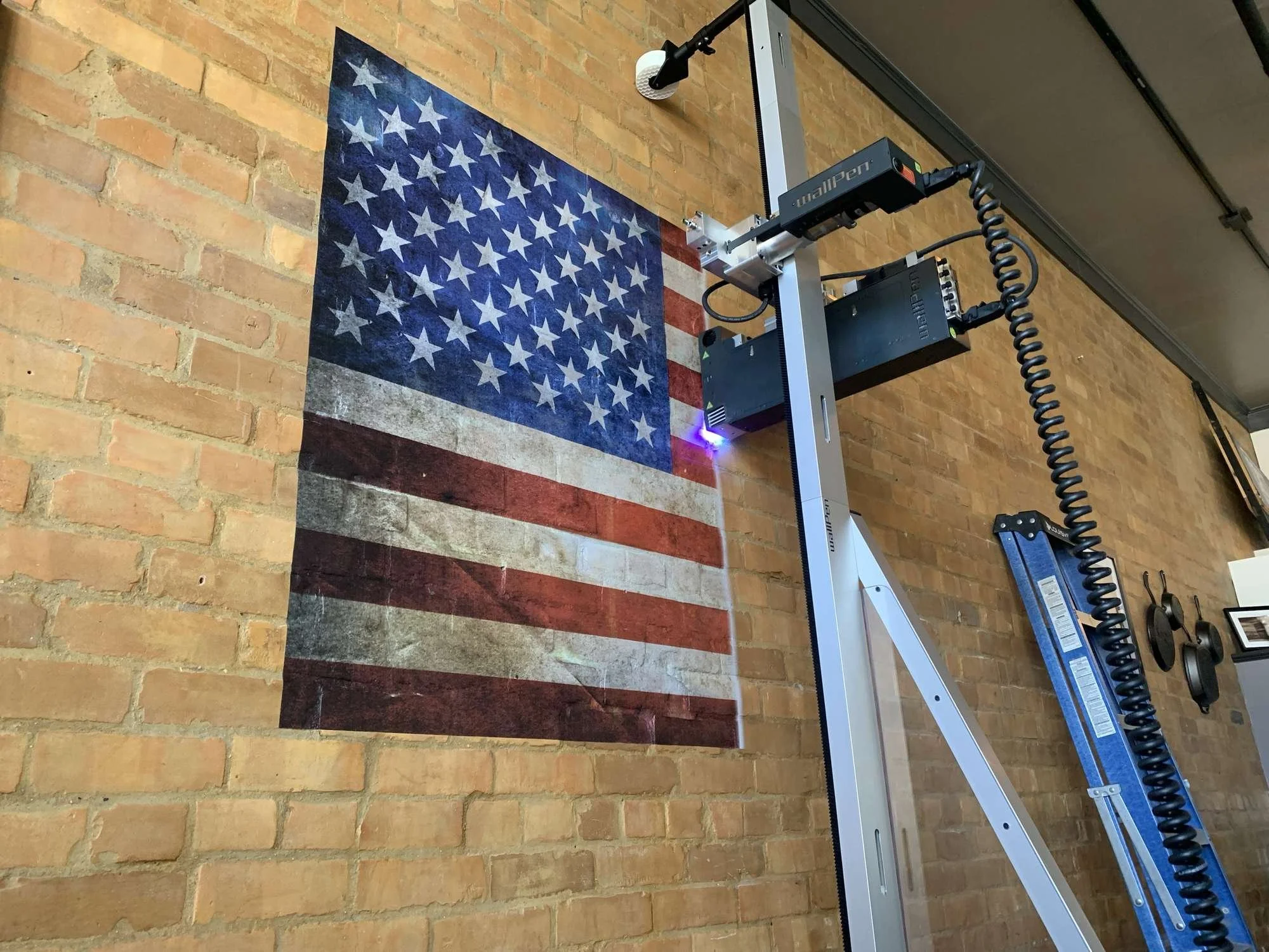 wallPen printer applying an American flag mural directly onto an exposed brick wall in a Utah restaurant