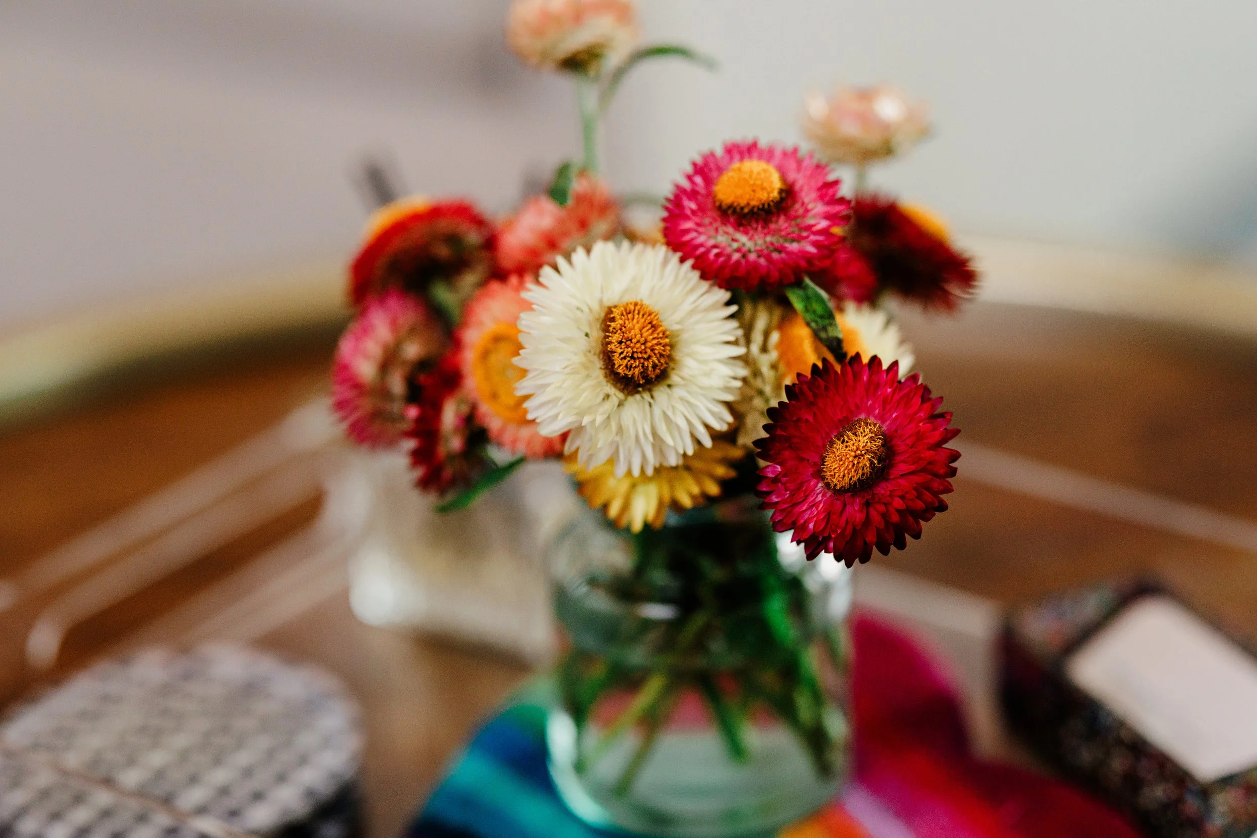 Colorful flowers in a glass vase on a table.
