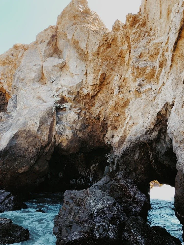 Sea caves with rugged rock formations and ocean waves crashing inside