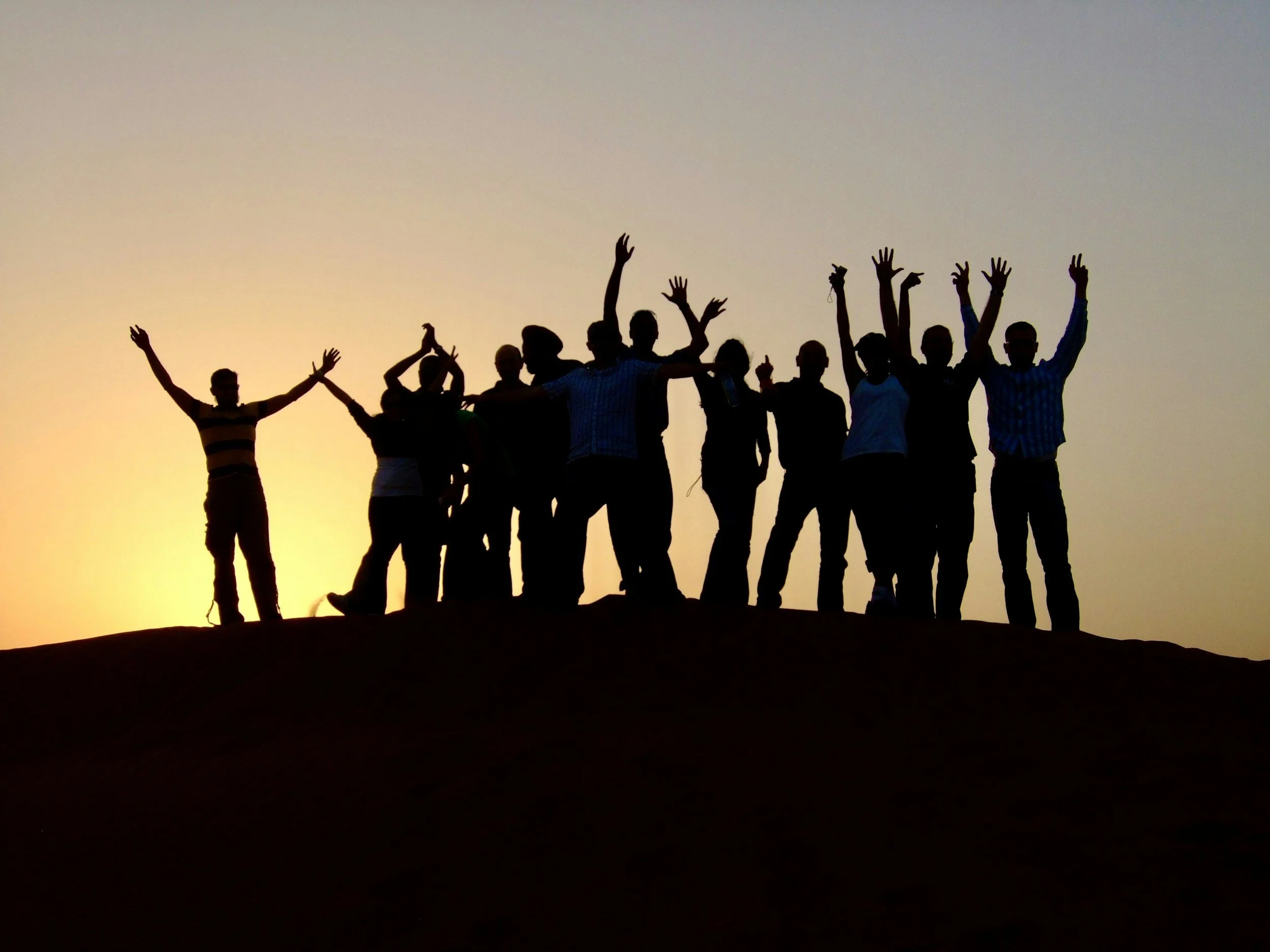 Stock image of the silhouette of a group of people at sunset.
