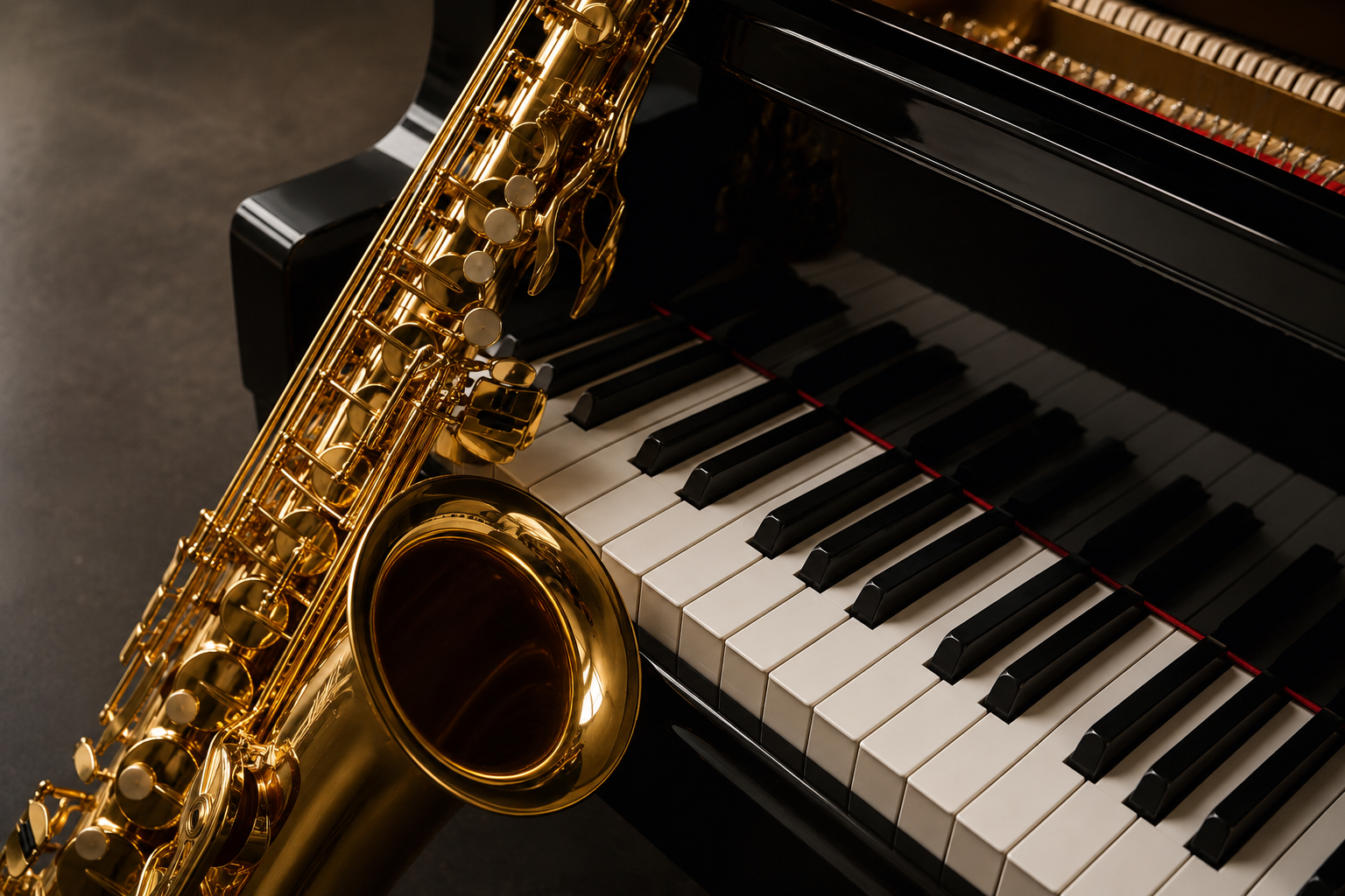 A close-up of a gold saxophone resting on a black grand piano keyboard.