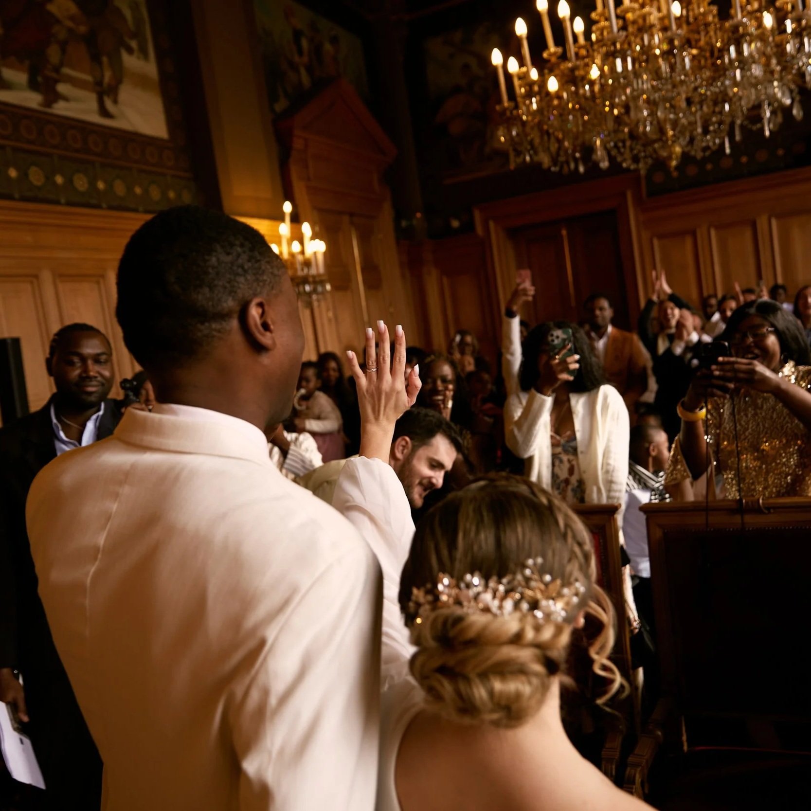 Cérémonie de mariage dans un salon d'honneur à Paris, mariés de dos face aux invités — photographe mariage Nicholas Efimtsev