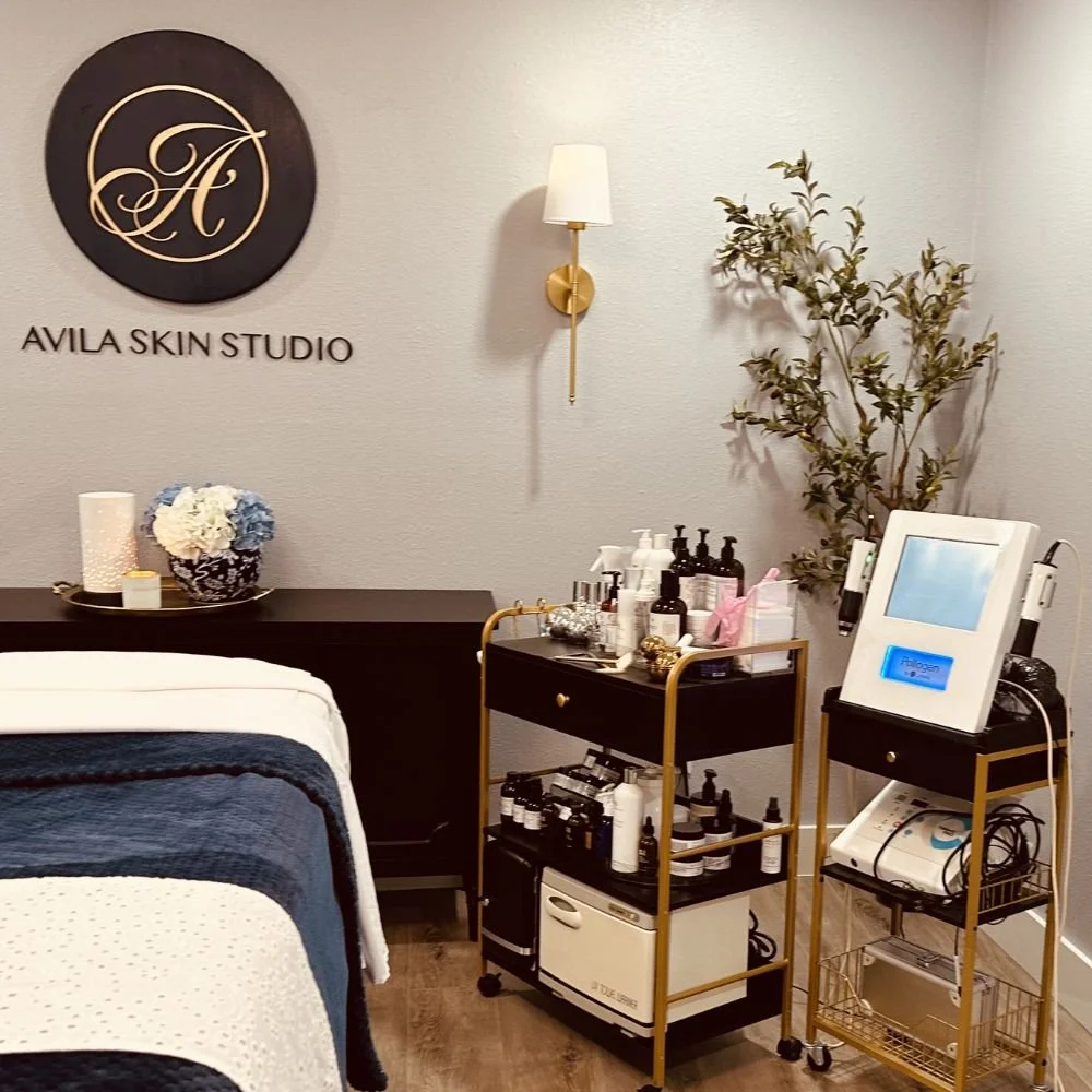 Interior of a skincare treatment room at Avila Skin Studio with a bed, skincare products, and equipment.