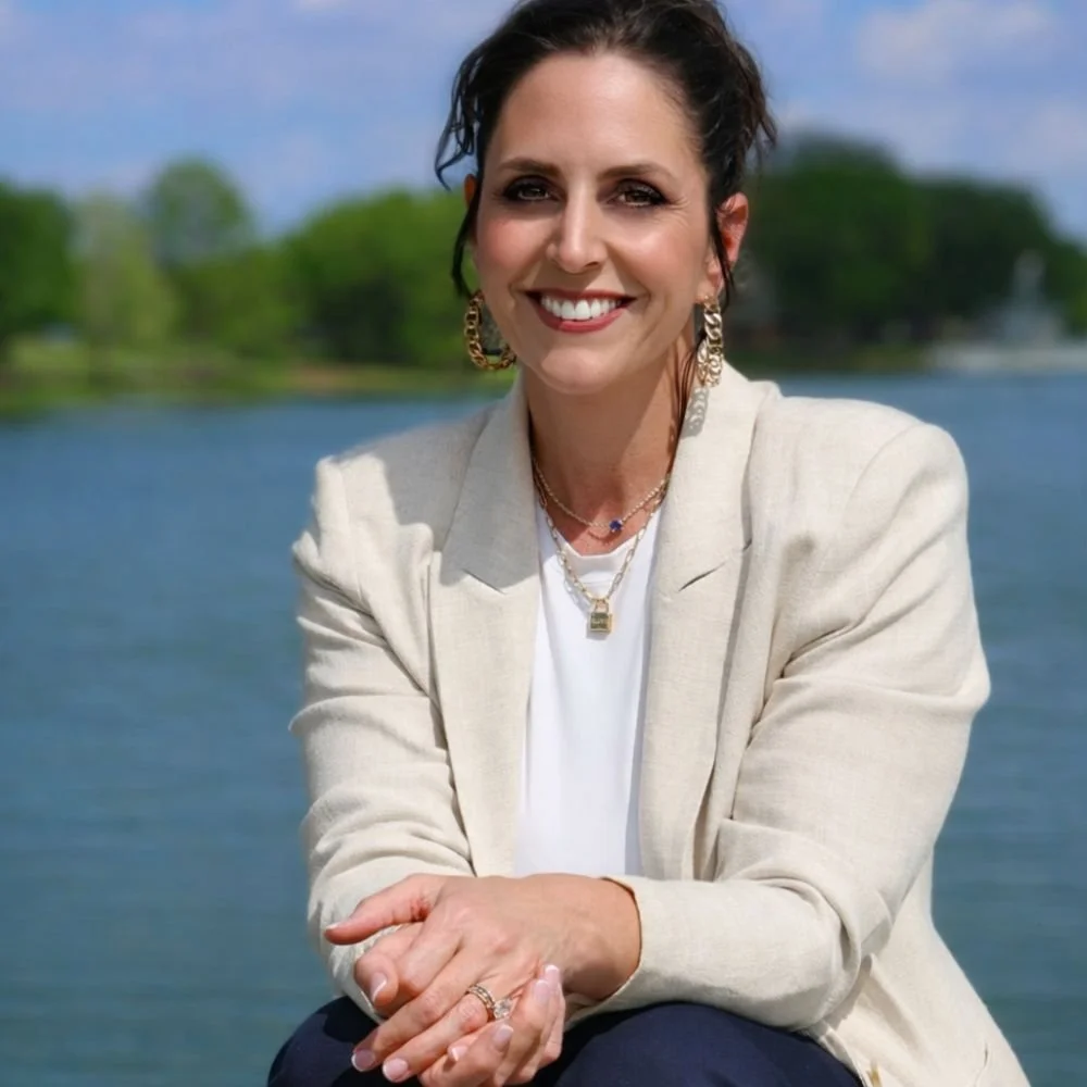 Amy Avila owner of Avila Skin Studio poses in front of a lake