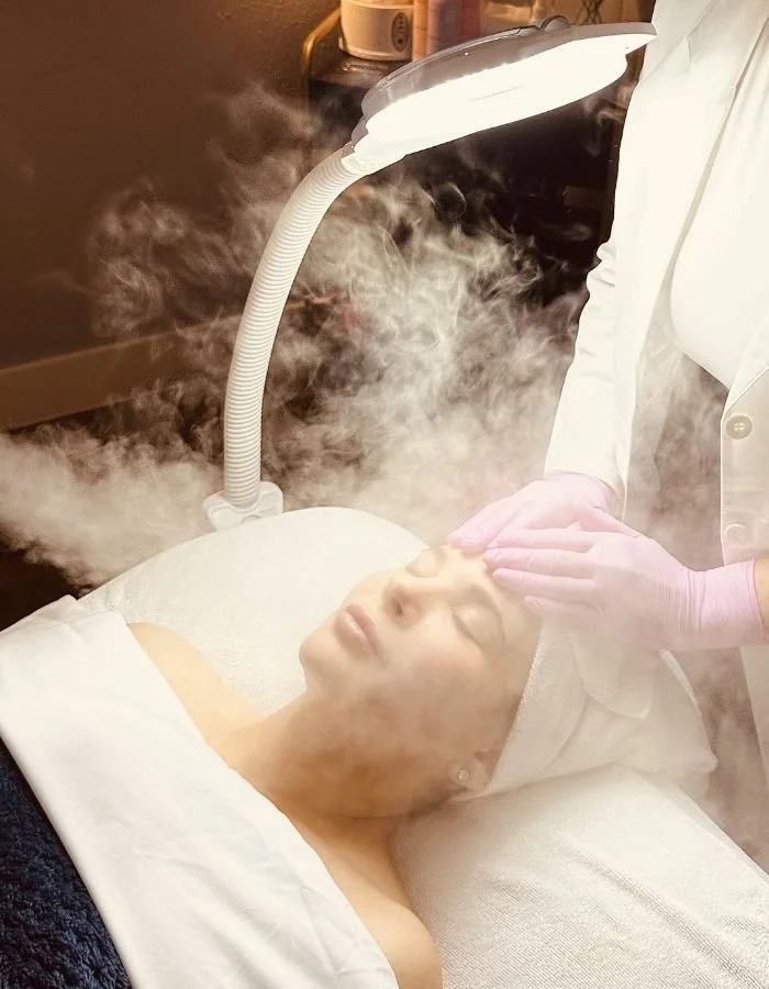 Female client enjoys the steam machine during a cutomized facial at Avila Skin Studio