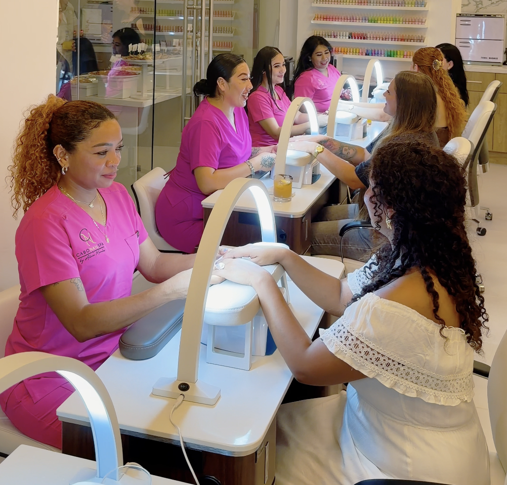 Mujeres recibiendo manicure en un salón de belleza.