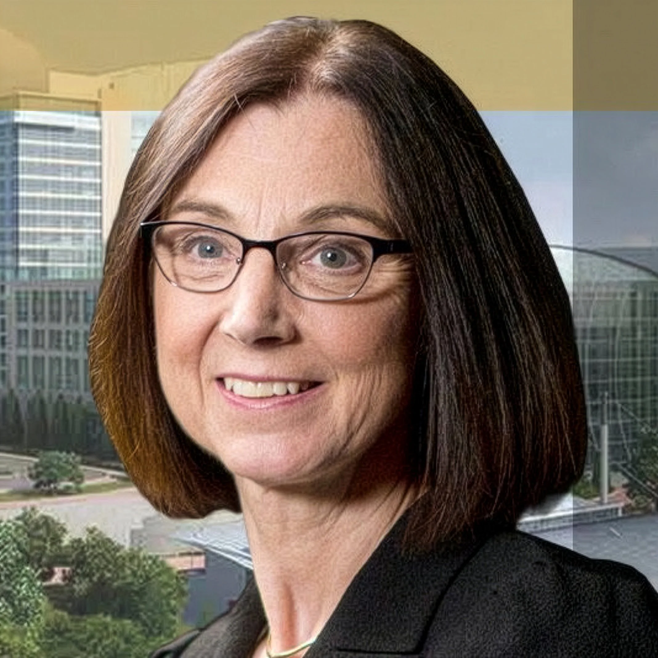Close-up of a smiling woman with brown hair, wearing glasses, standing outdoors with modern buildings and greenery in the background.