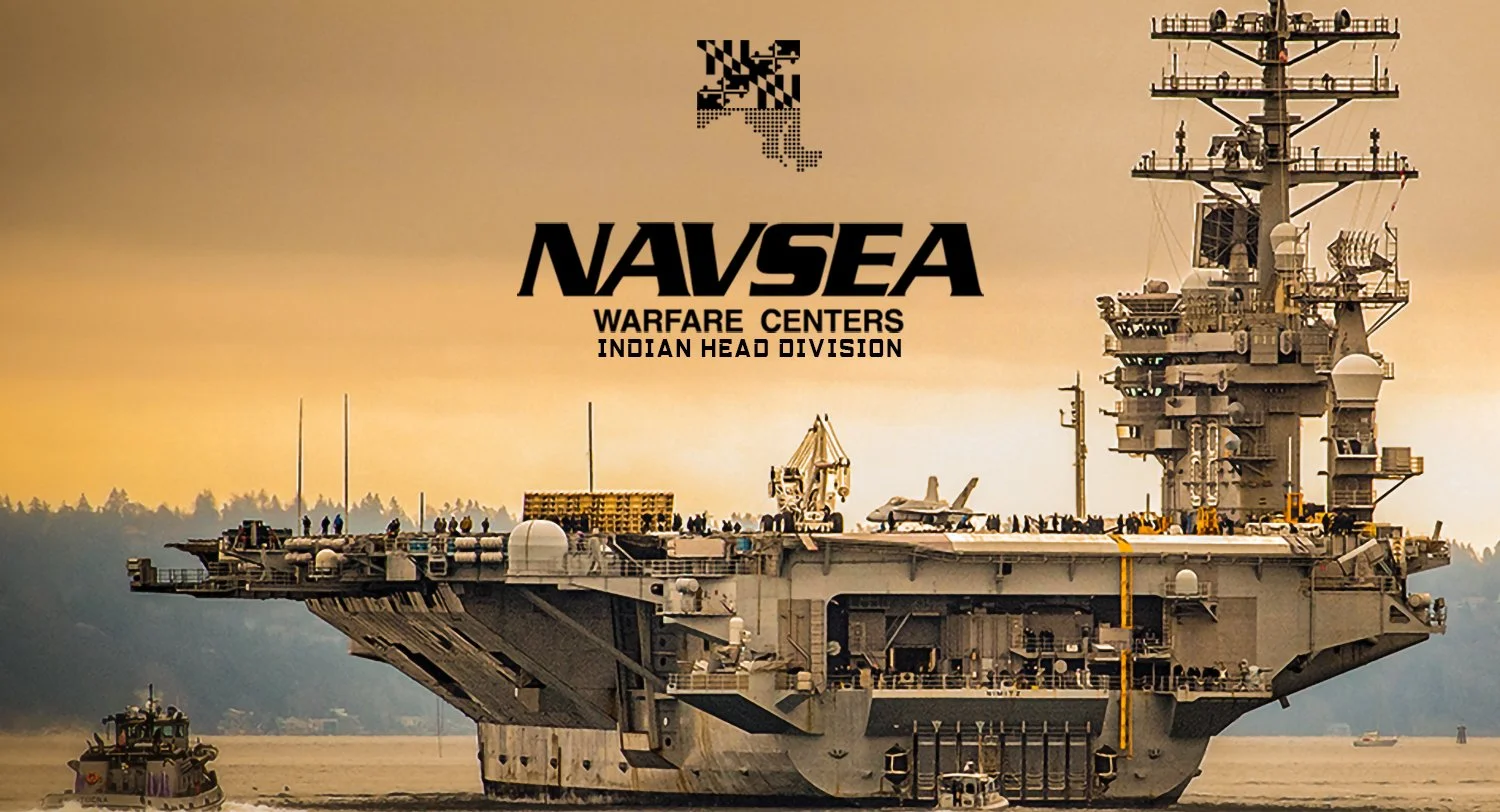 A large aircraft carrier with a helipad and a jet on deck, sailing on water with a towing boat nearby, under an orange sky, with the text 'NAVSEA Warfare Centers Indian Head Division'.