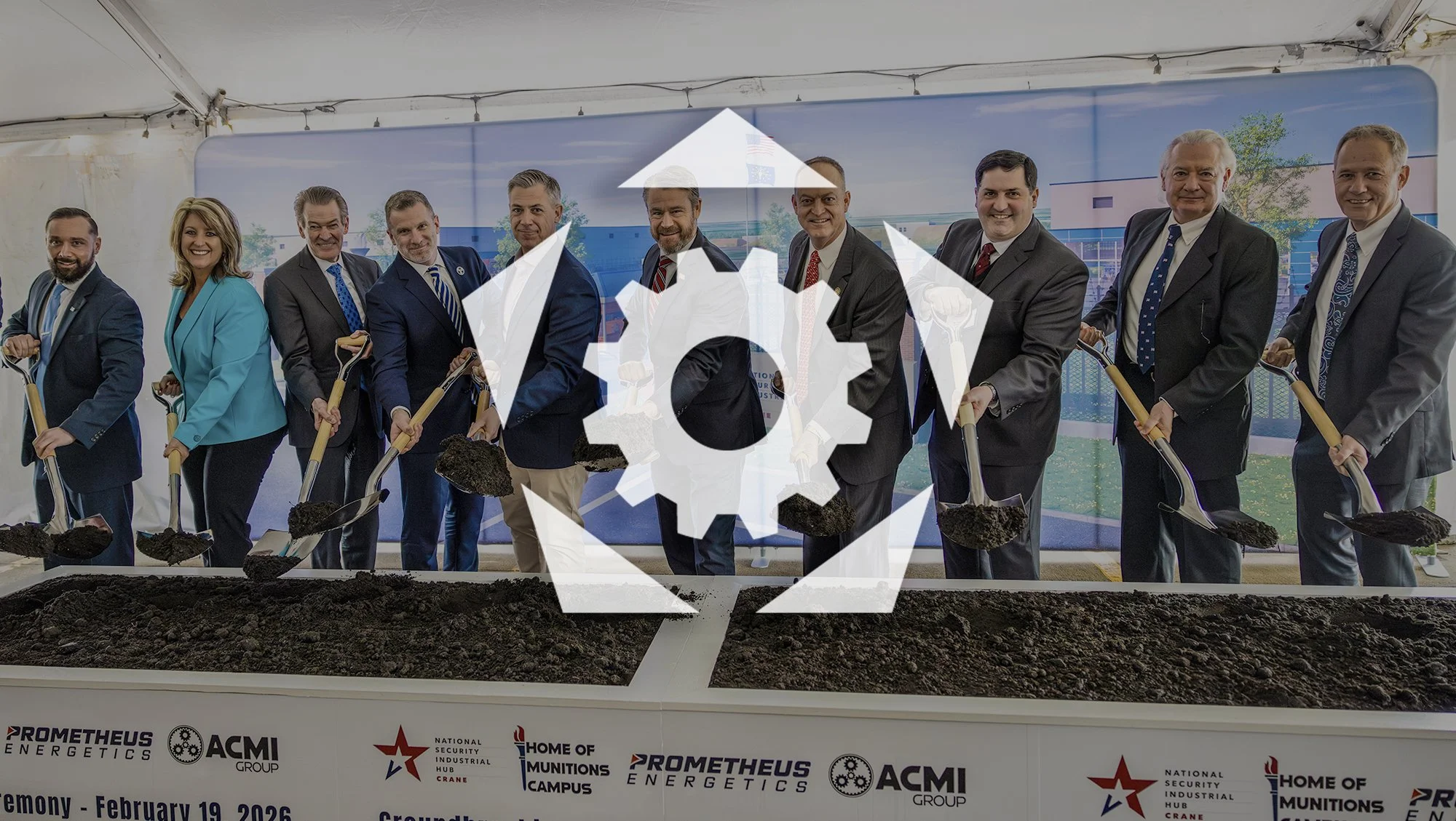 Group of people in business attire breaking ground with shovels at a groundbreaking ceremony for a new building.