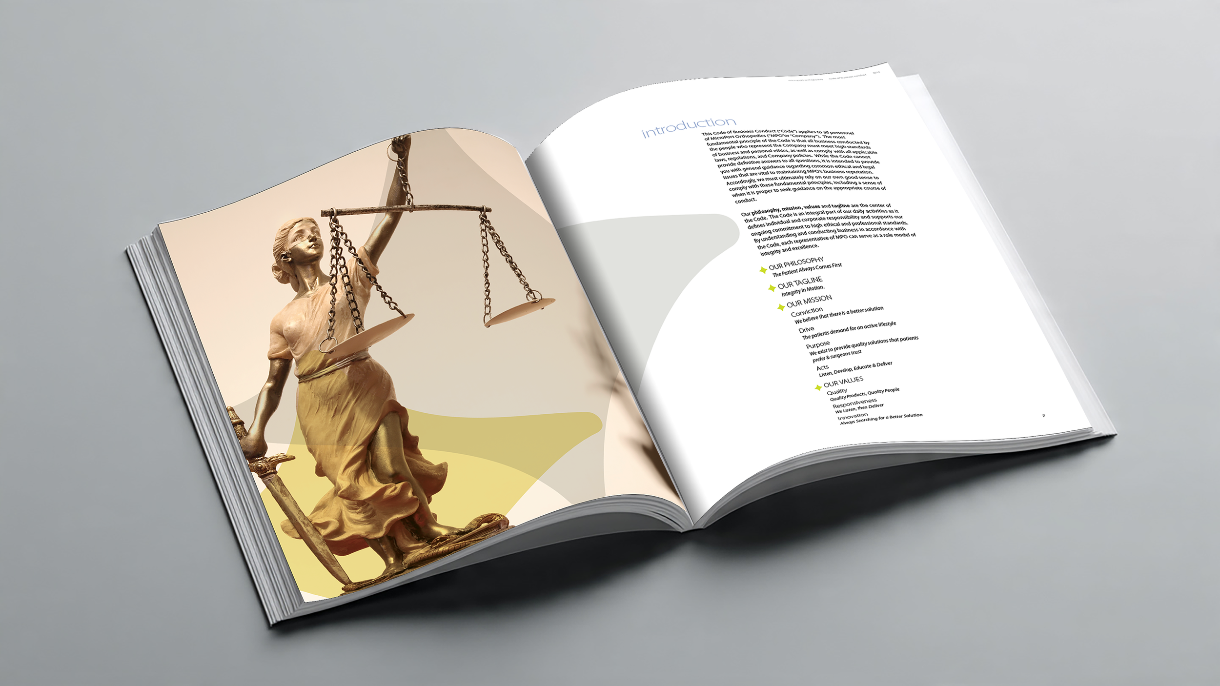 An open booklet displaying a photograph of a golden statue of Lady Justice holding scales, with the text on the right page discussing company values and philosophy.