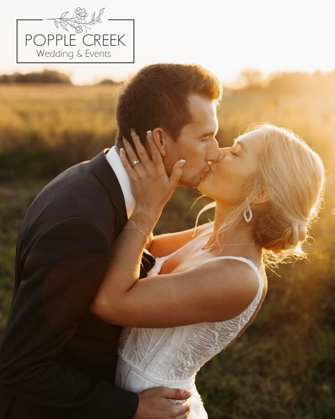 A bride and groom sharing a kiss outdoors during sunset, with the bride wearing a white wedding dress and the groom in a black suit.