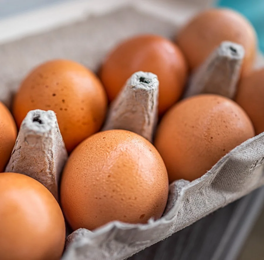 Close-up of brown eggs in a cardboard egg carton.