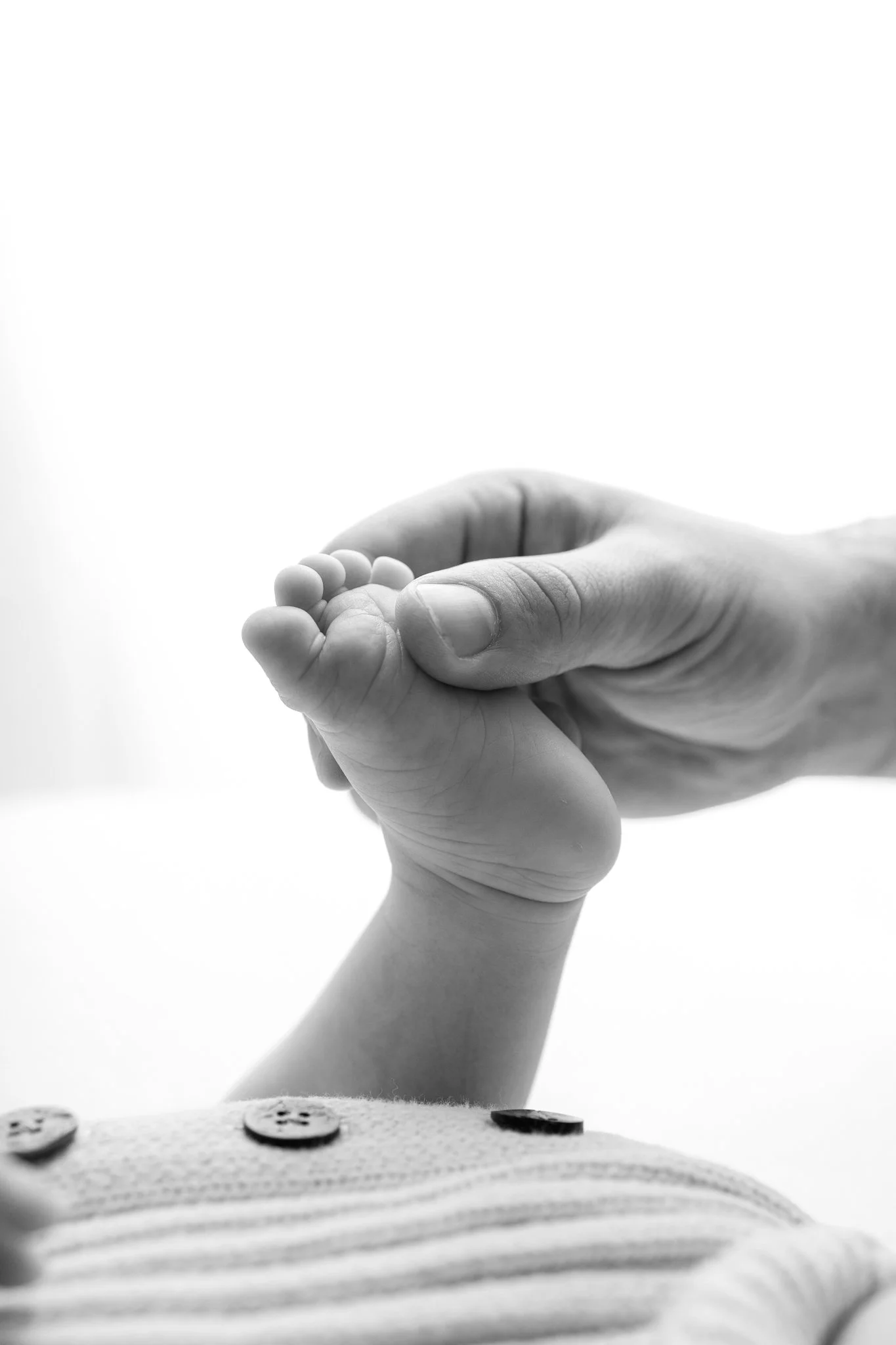 Newborn baby foot being held by parent hand at Fresh 48 photoshoot in Melbourne