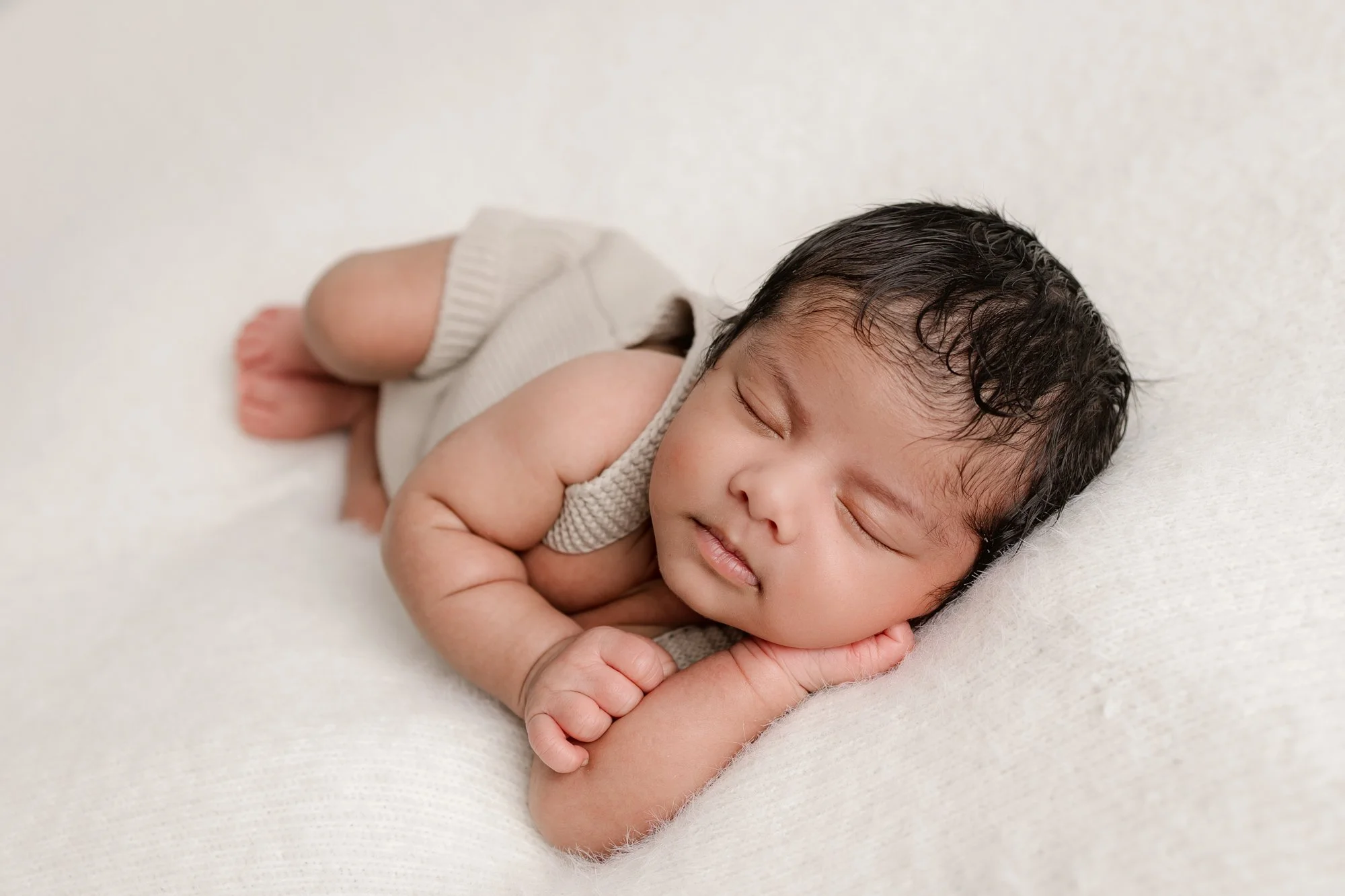 Newborn laying on a soft neutral blanket at his newborn photography session in Werribee