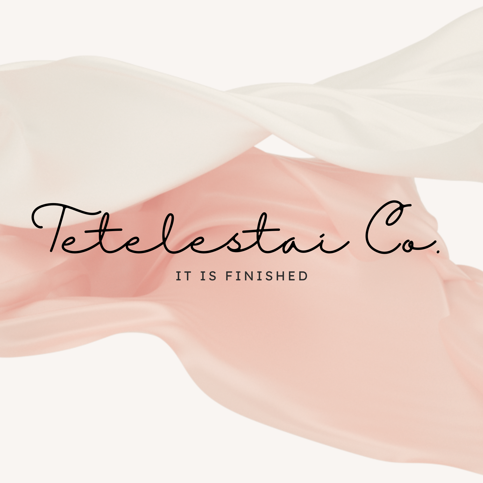 Close-up of a soft pink and white surface with elegant cursive text reading 'Tetelestai Co.' and smaller text 'IT IS FINISHED'.