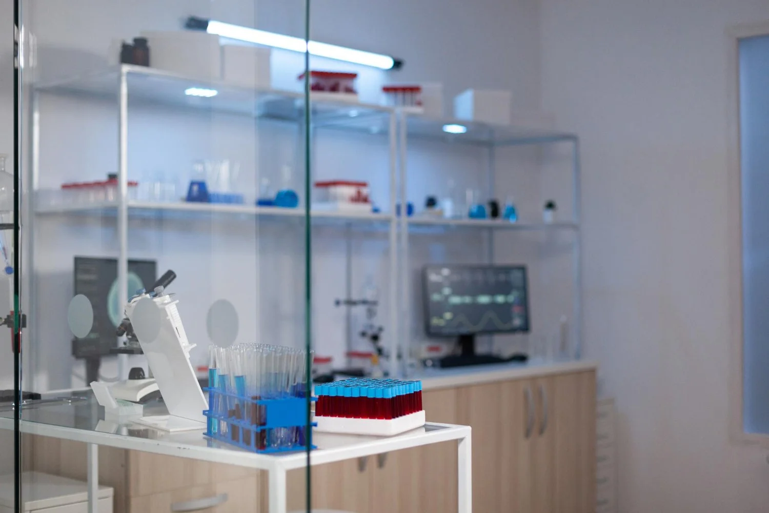 Modern roots healthcare of a laboratory with test tubes, a microscope, and lab equipment on a white table, and shelves with lab supplies in the background.