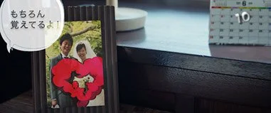スマートフォンの画面に、花とハートの飾り、二人の子どもと大人の写真。