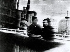 二人の男性が海や港の背景に立っている古い写真