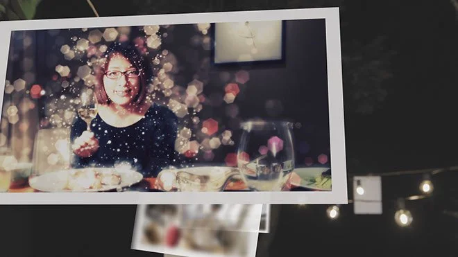 写真には女性の人物が笑顔で写っており、その周りに光のエフェクトやぼかし効果が施されている。