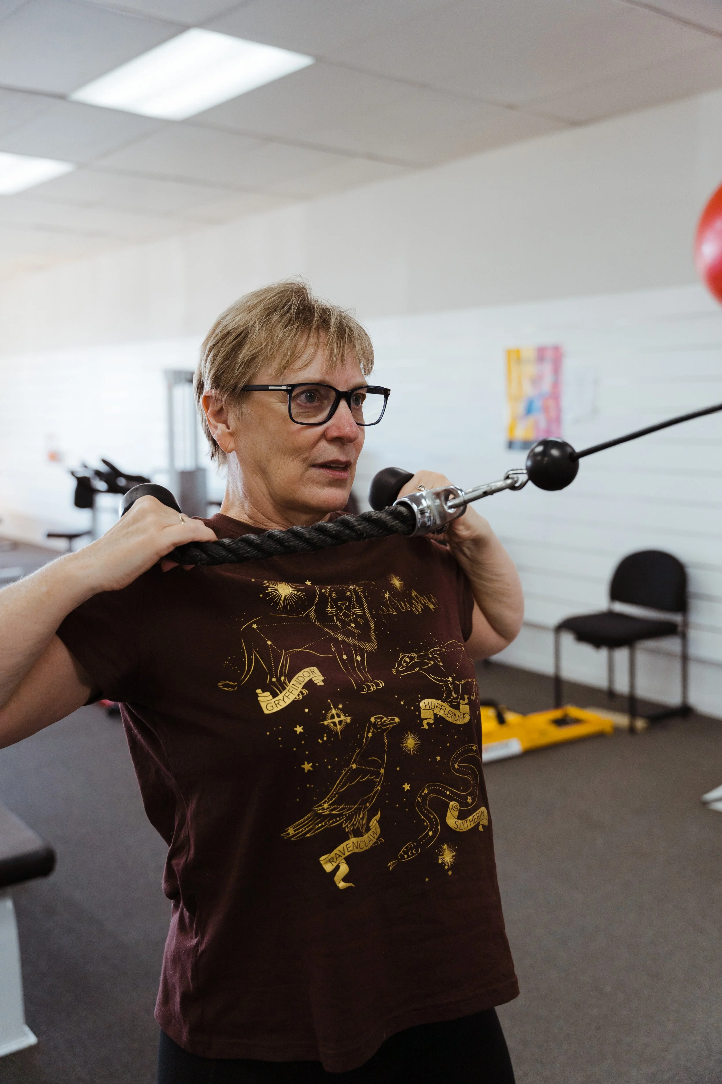 Woman performing a resistance exercise with a rope at the gym.