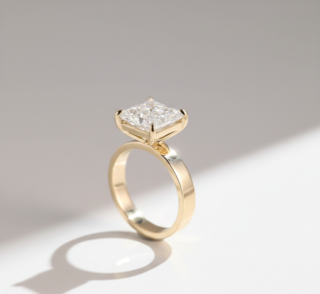 Gold ring with a large, square-cut diamond solitaire setting.