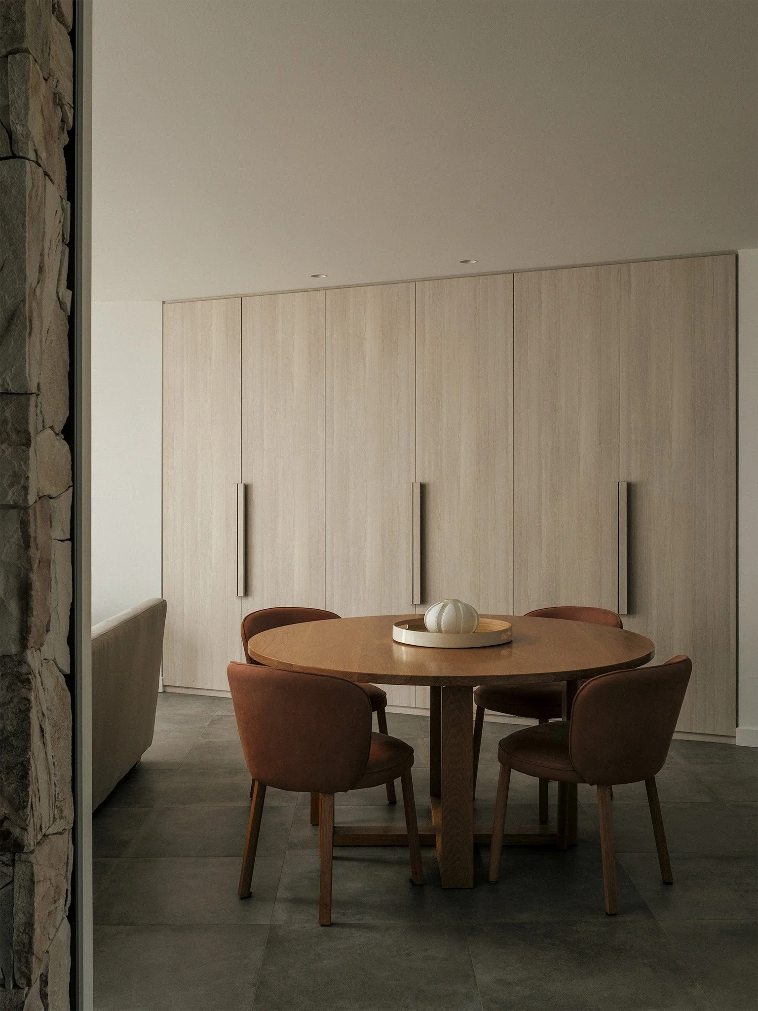 Modern kitchen design showcasing warm ambient lighting, a solid wood table, and integrated oak storage units.