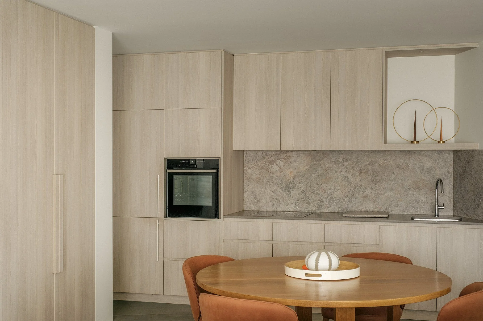 Modern secondary kitchen featuring custom oak cabinetry and minimalist timber storage.