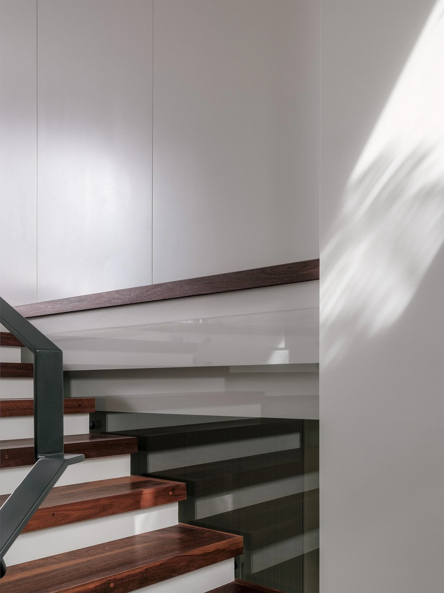 Modern architect-designed home interior featuring timber staircase with steel handrail and minimalist detailing.