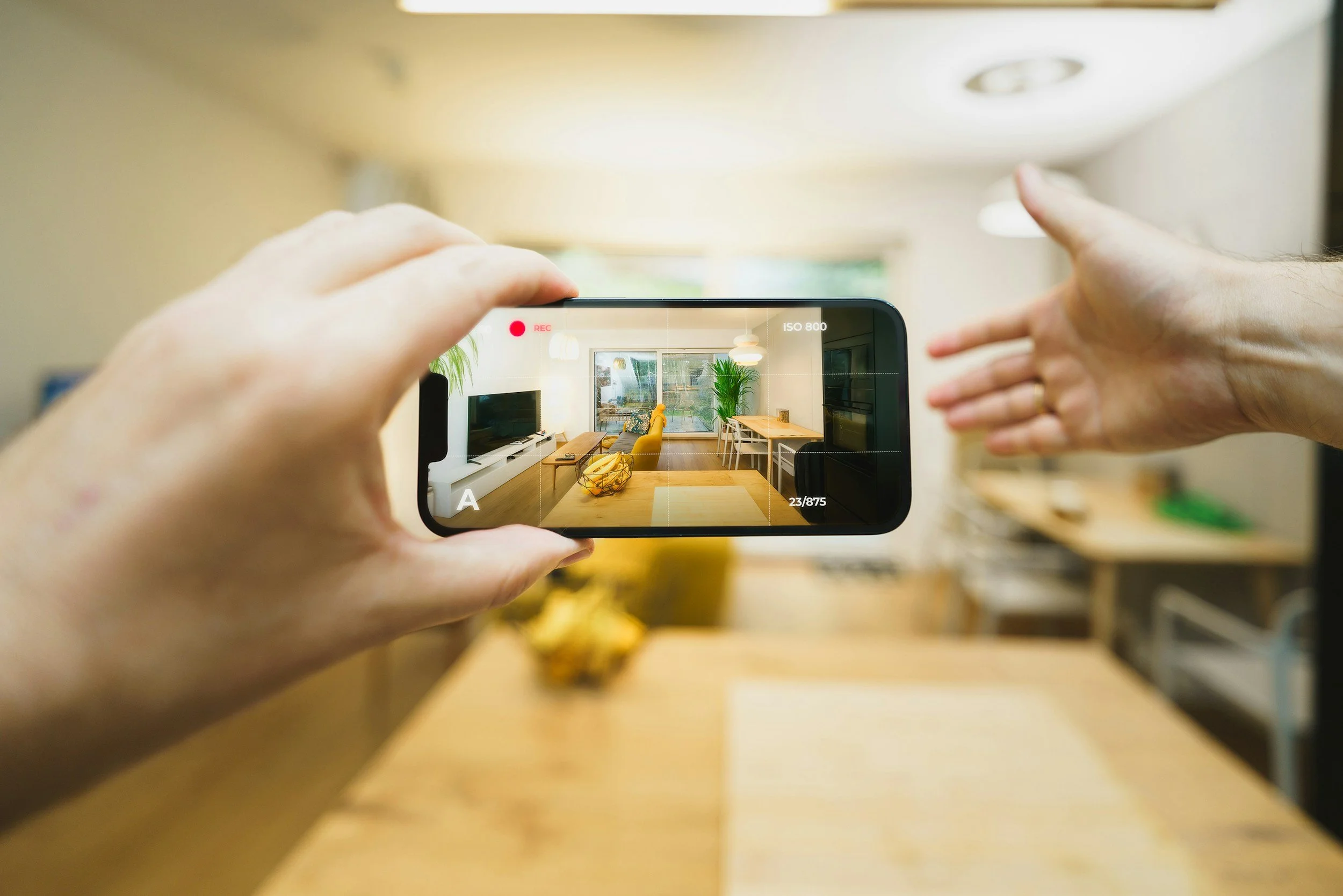 Asesor inmobiliario  tomando una fotografía de un interior de sala de estar.