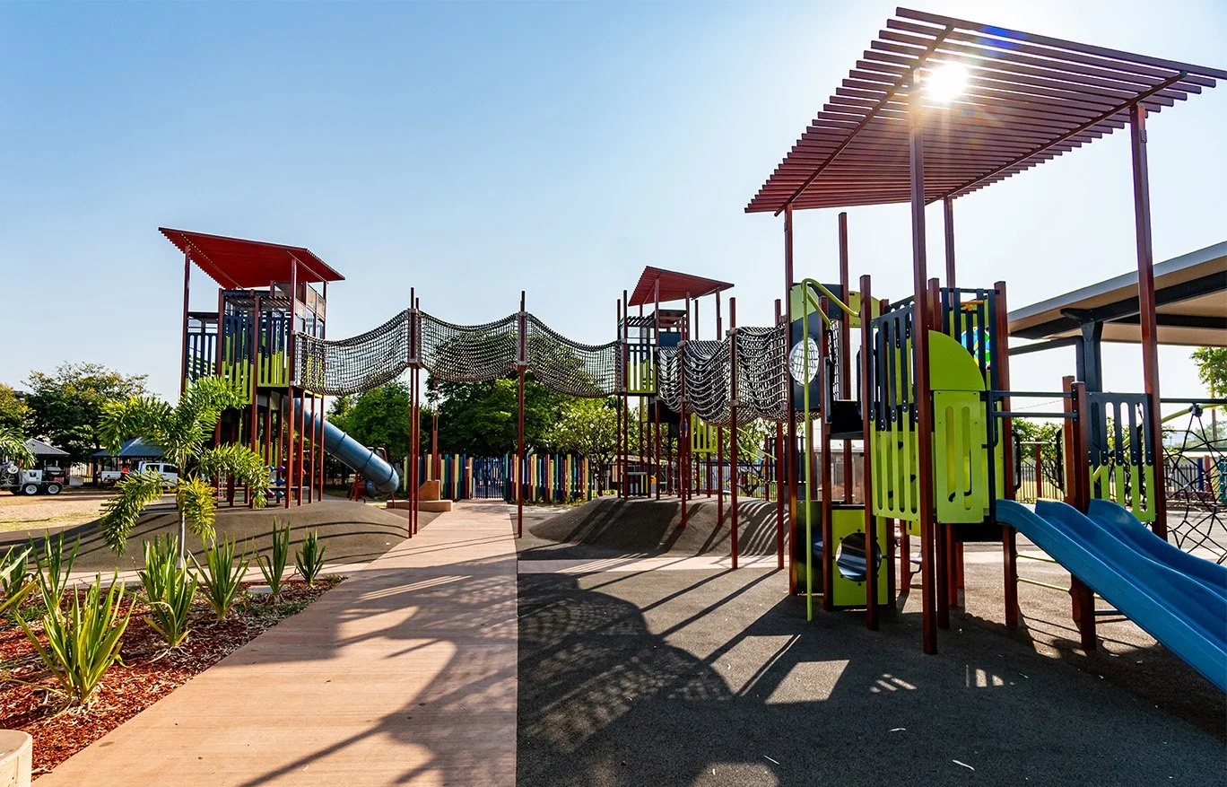 Colorful playground at the Family Fun Park in Mount Isa with slides, climbing structures, and bridges on a sunny day.