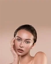 Close-up portrait of a woman with styled hair and natural makeup, touching her face with her hand