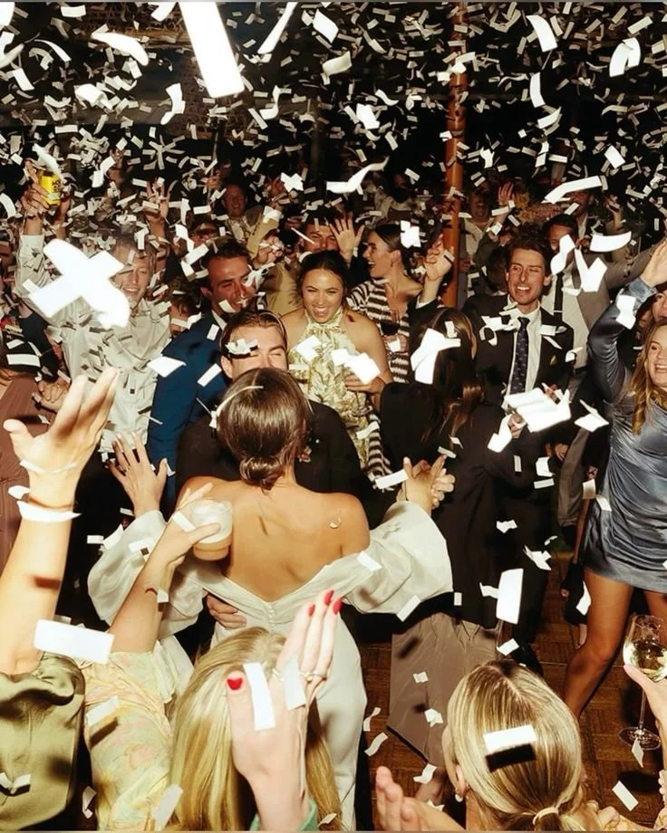 People celebrating with confetti falling at a party or event.