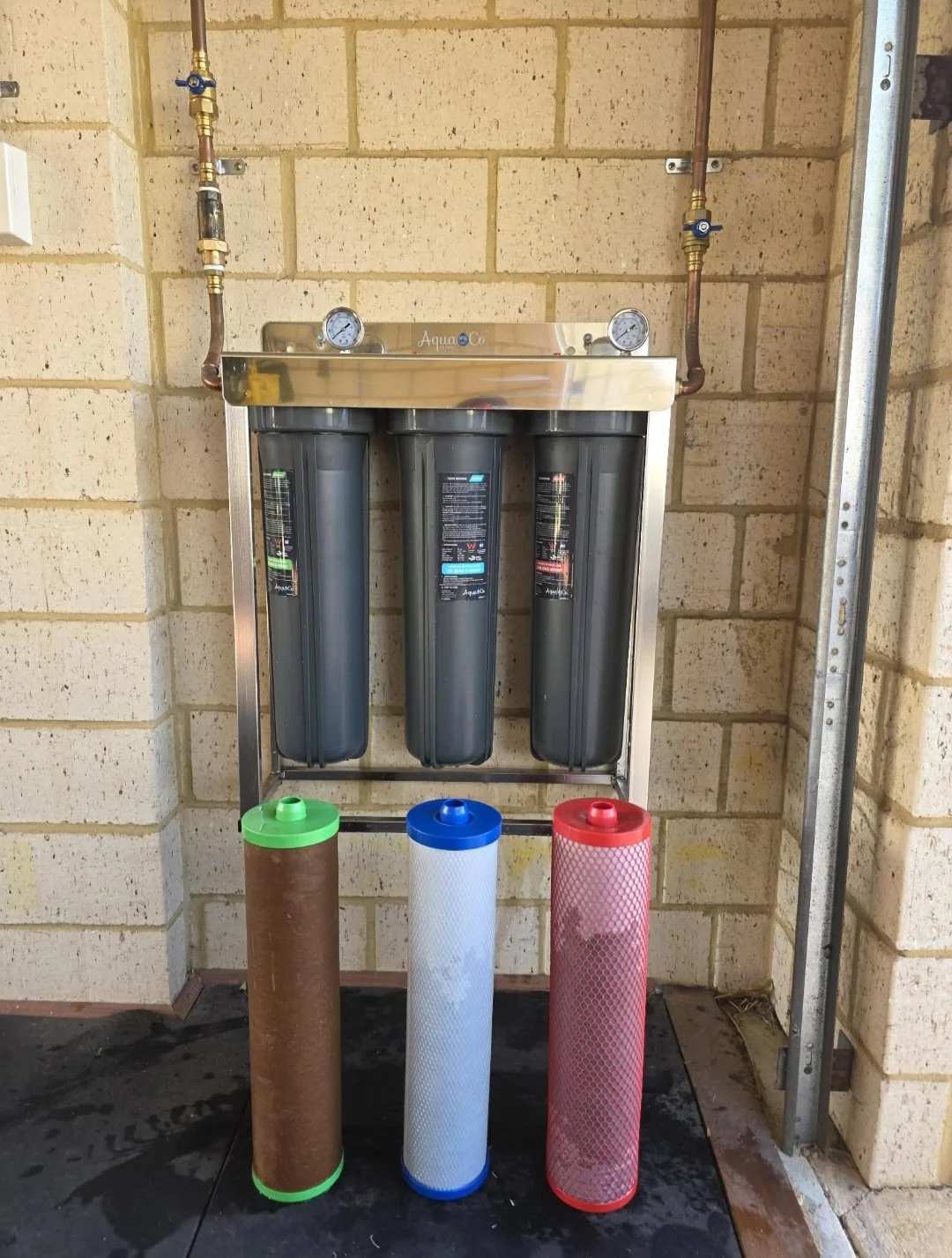 Water filtration system with three filter cartridges installed and three additional cartridges placed in front. Installed by a Singleton WA plumber.