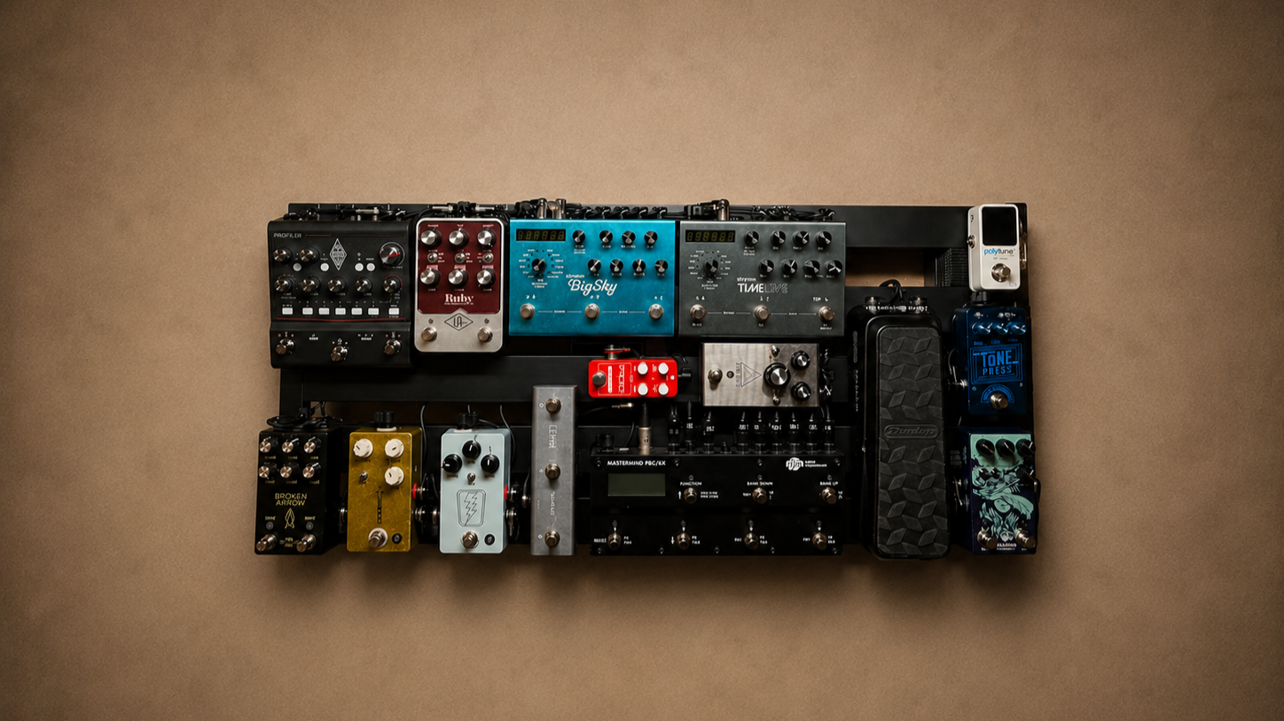 A wall-mounted array of various guitar effect pedals on a black board, including delay, reverb, overdrive, and modulation pedals, with a beige background.
