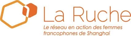 Logo for La Ruche, a network of French-speaking women in Shanghai, featuring a hexagonal honeycomb shape and orange text.