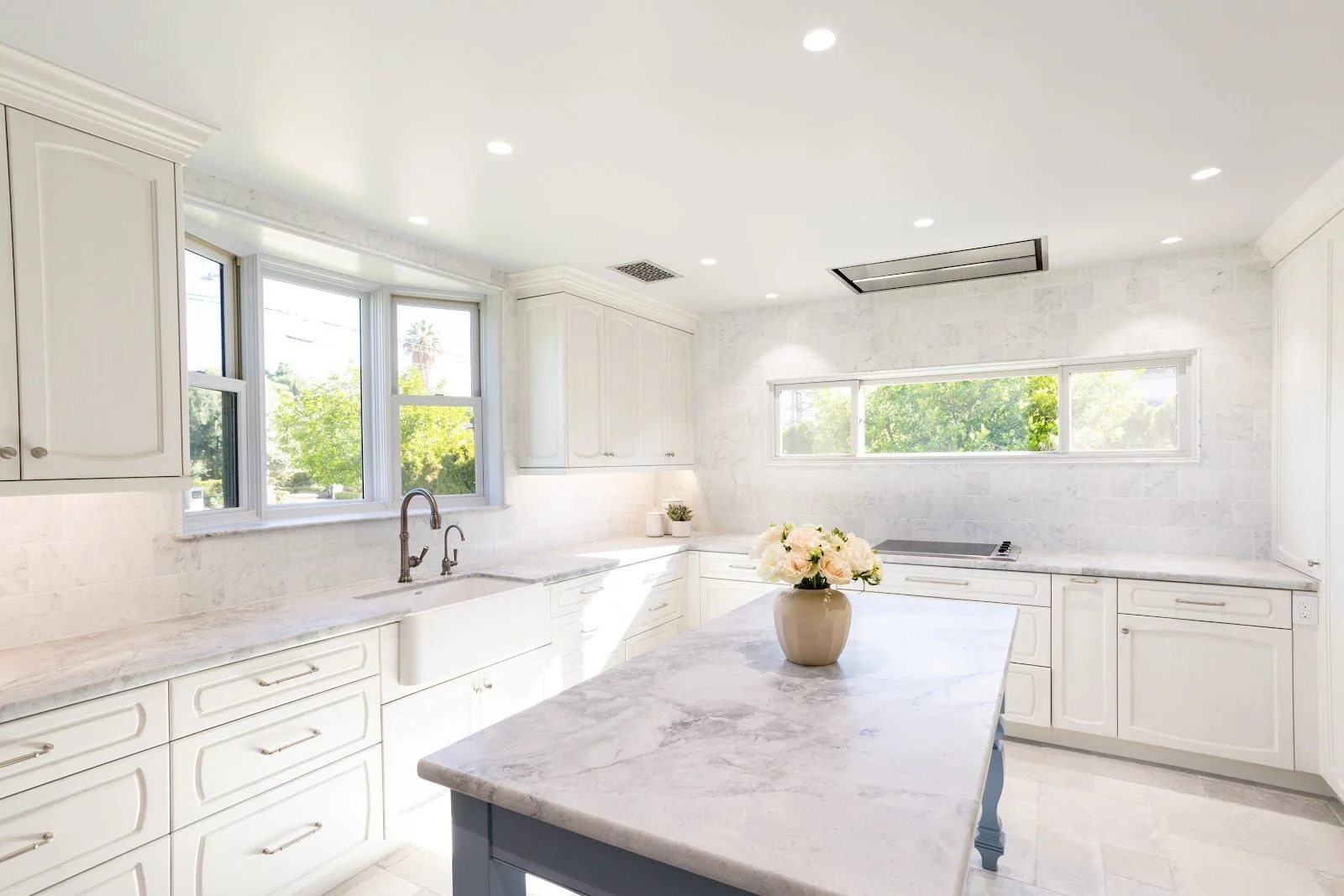 Sage green laundry room cabinetry with a window and stacked appliances