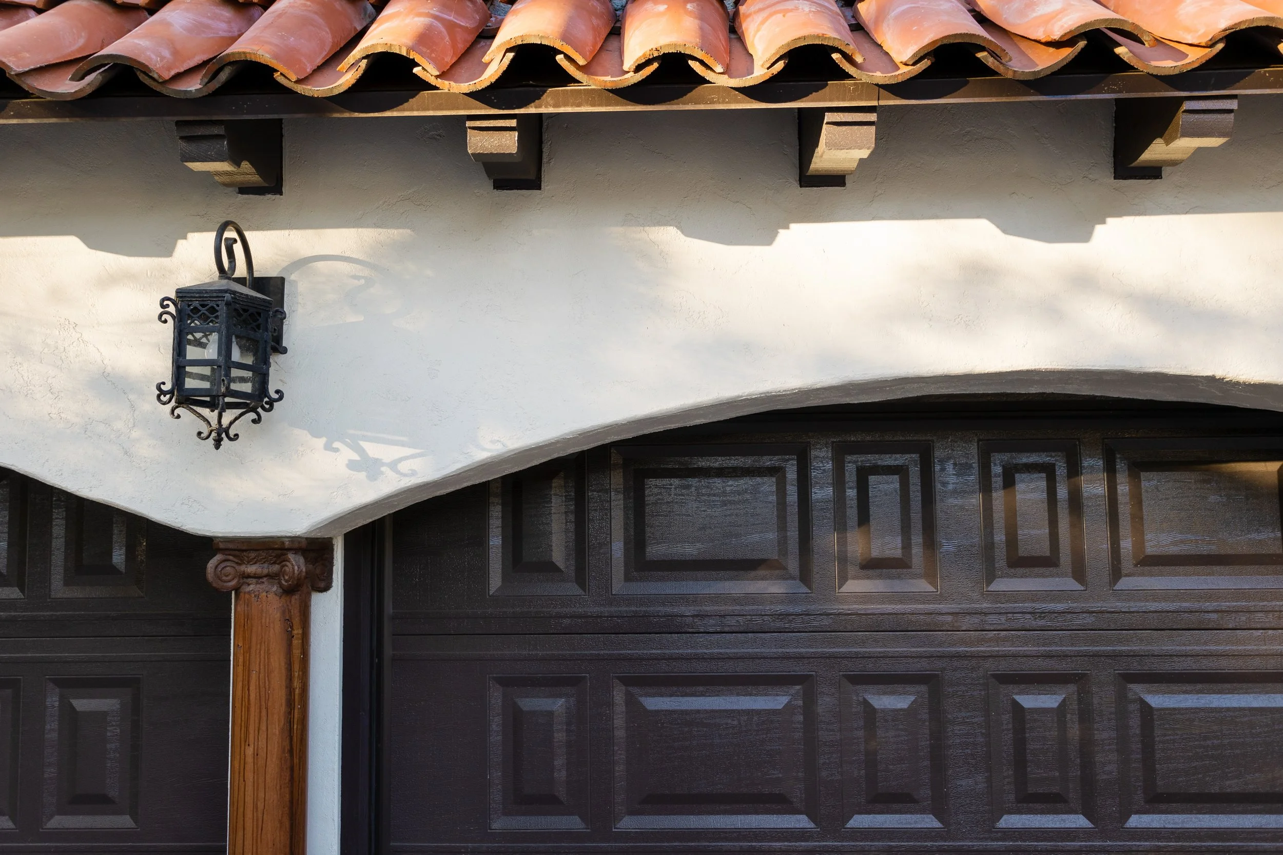 Exterior lantern beneath red roof tiles and dark wood eaves