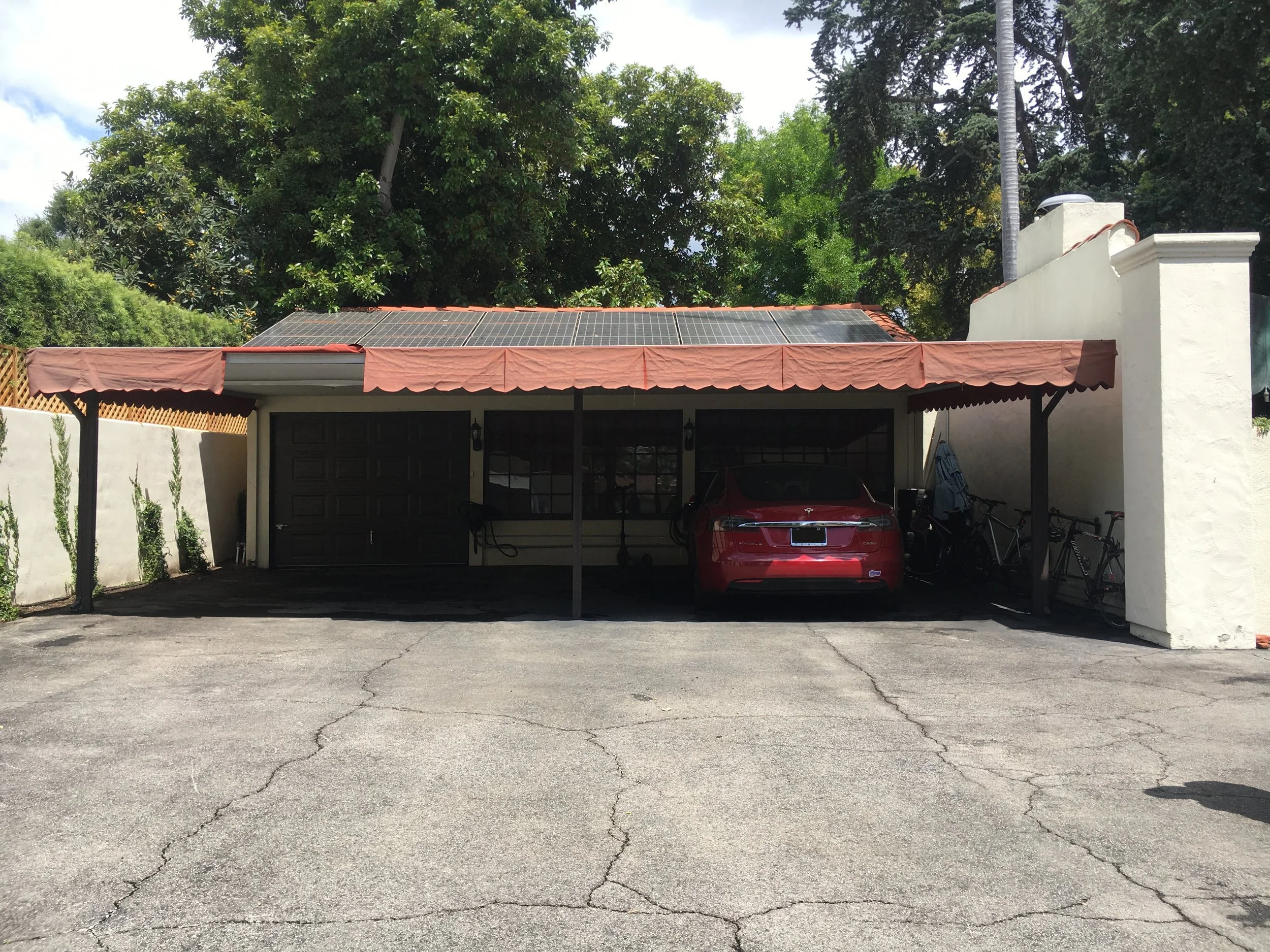 Three-bay carport with red awnings before renovation