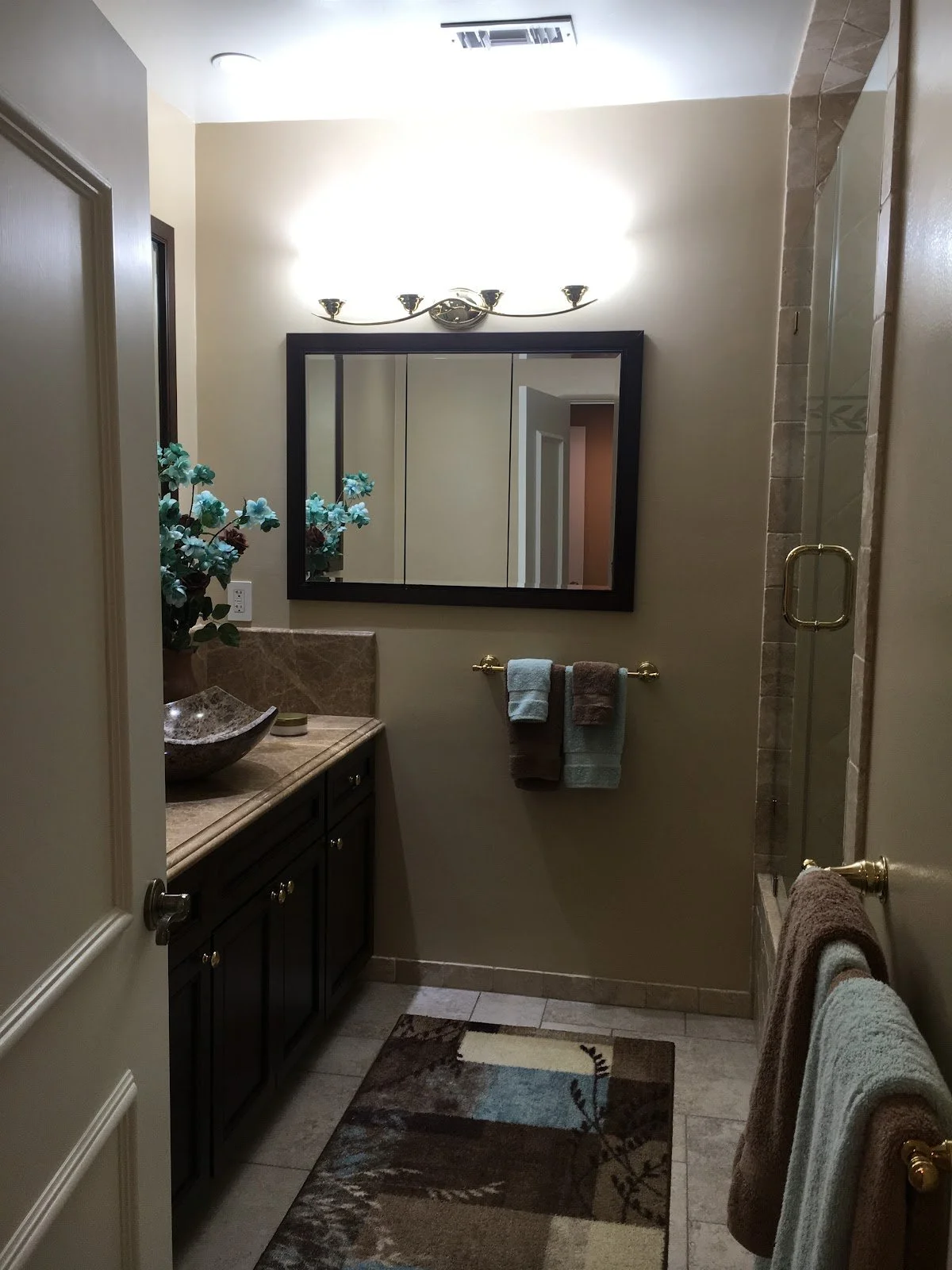 Powder room with vessel sink and dark wood vanity before renovation