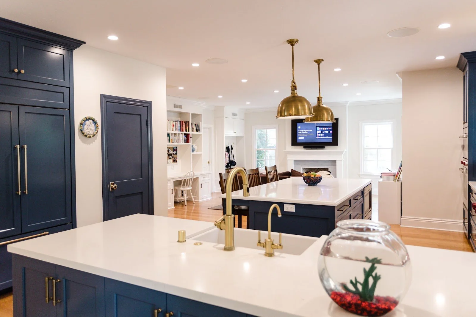 Open-plan kitchen and living space with navy doors and white cabinetry