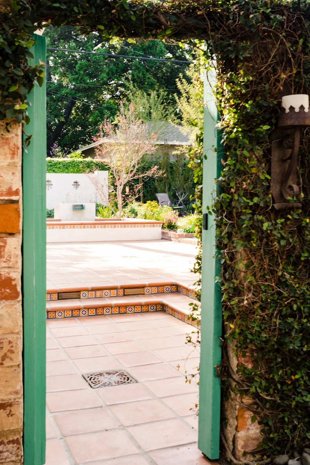 Terracotta patio steps framed by a turquoise garden gate