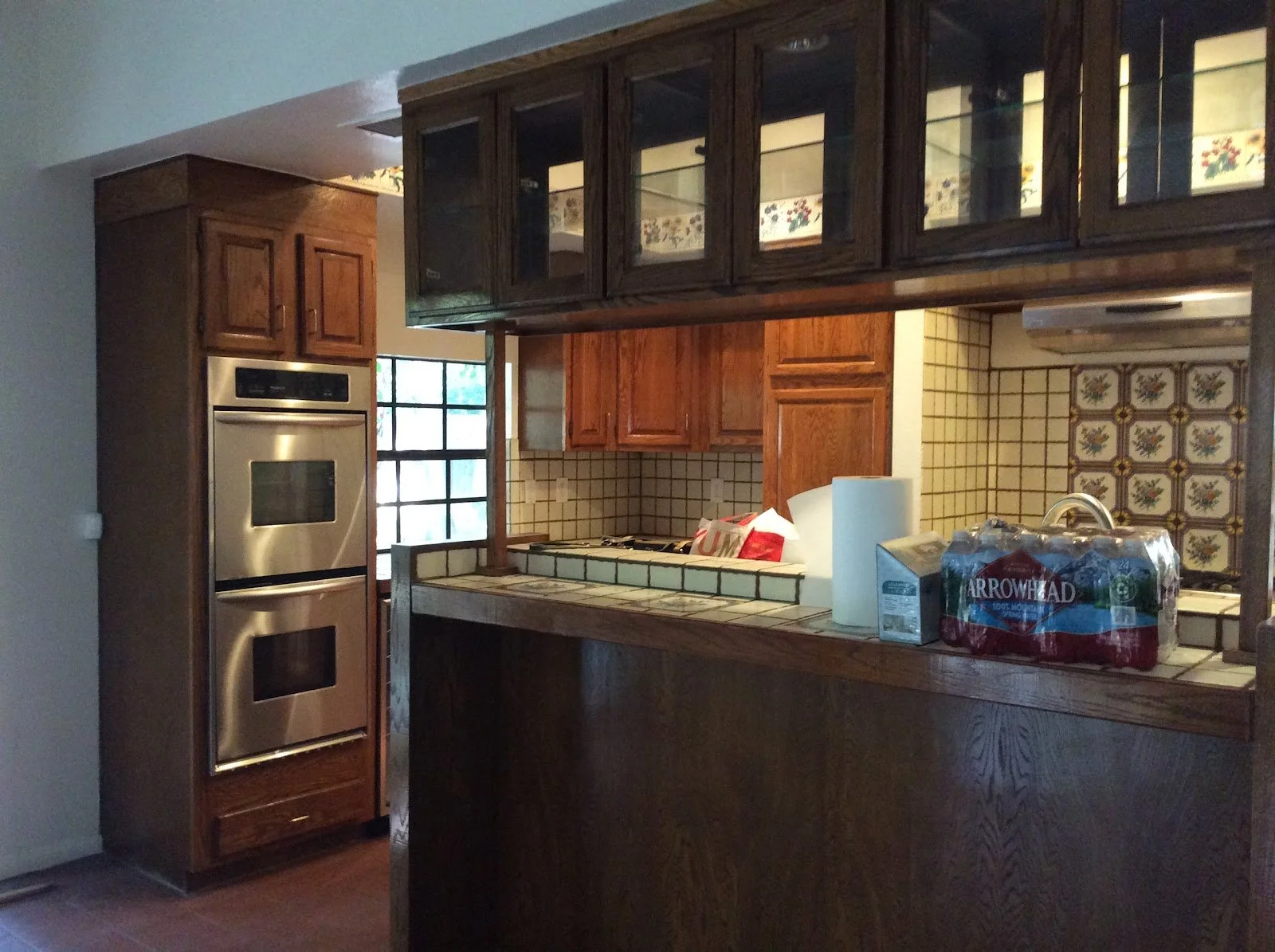 Dated kitchen with dark wood cabinets and tiled countertops before renovation
