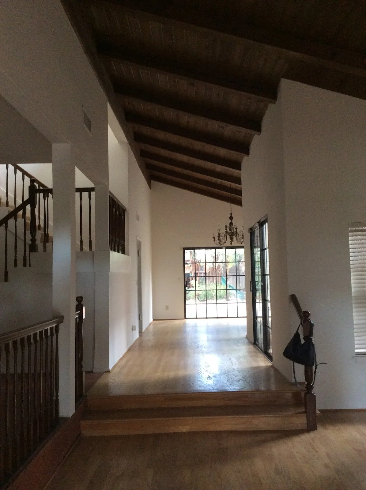 Two-story hallway with dark wood railings before renovation