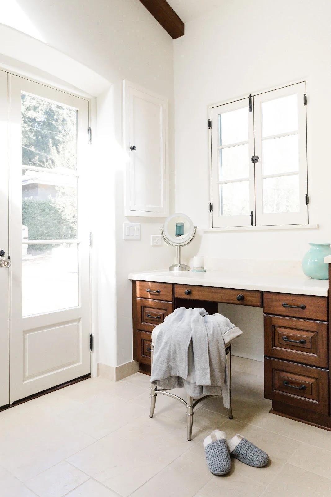 Dark wood dressing vanity beside a glass-paneled exterior door